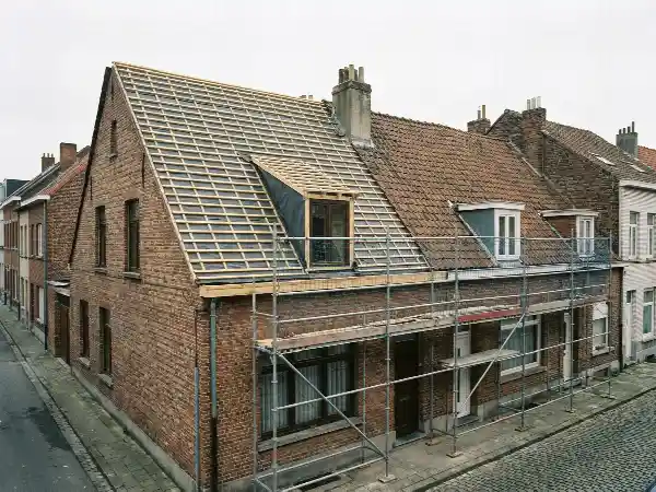 Maison de rangée dont un versant est déjà dépouillé et relatté
